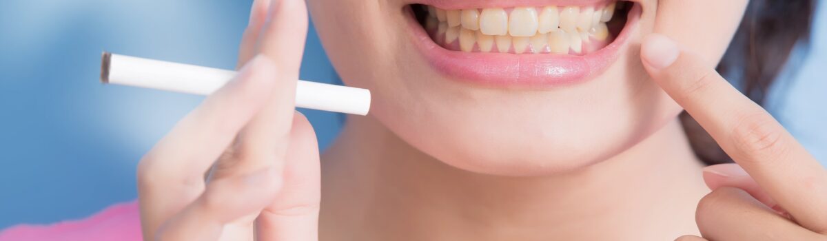 Vrouw laat gele tanden zien en slechte mondgezondheid door sigaret